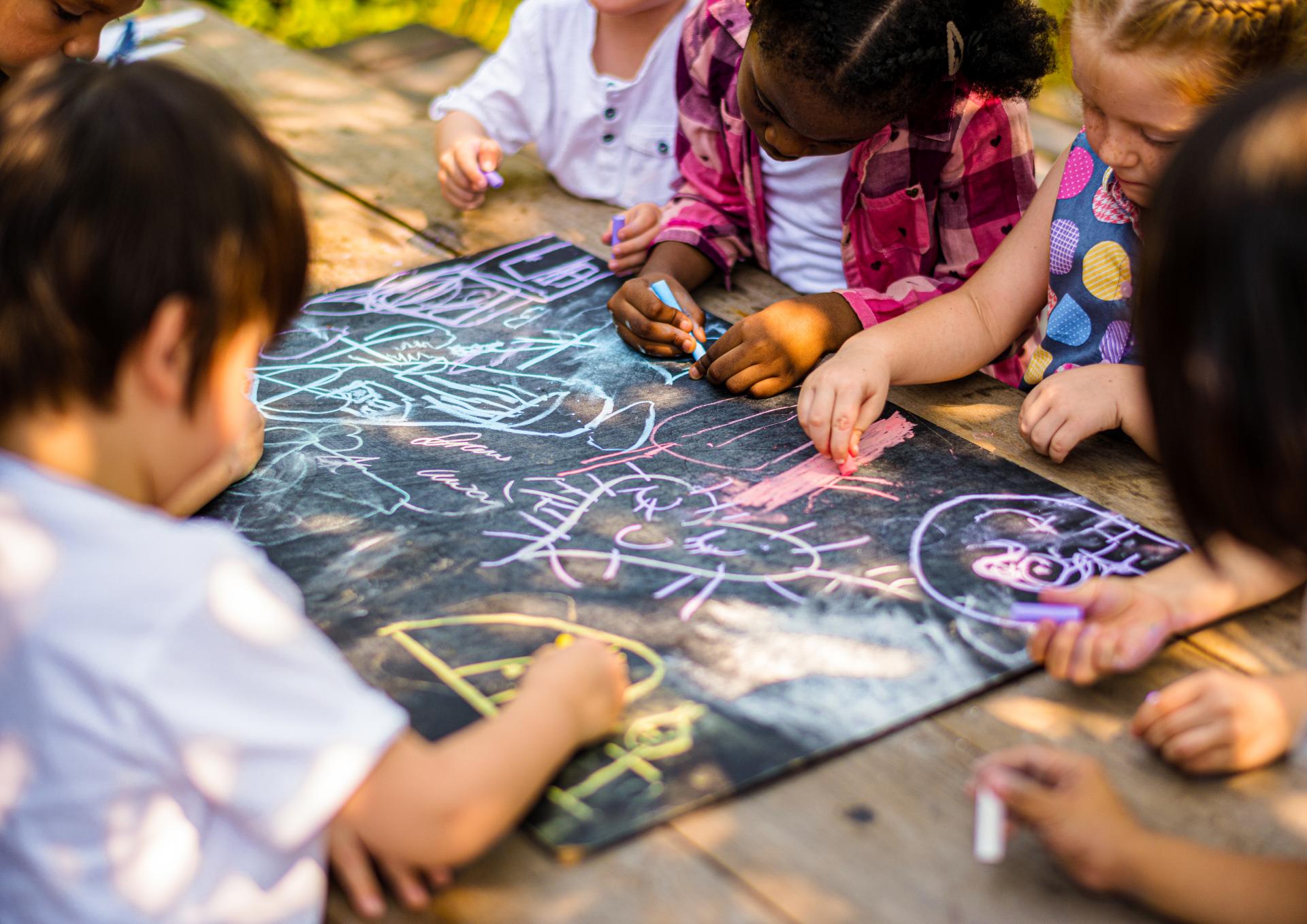 Kids drawing with chalk on a blackboard