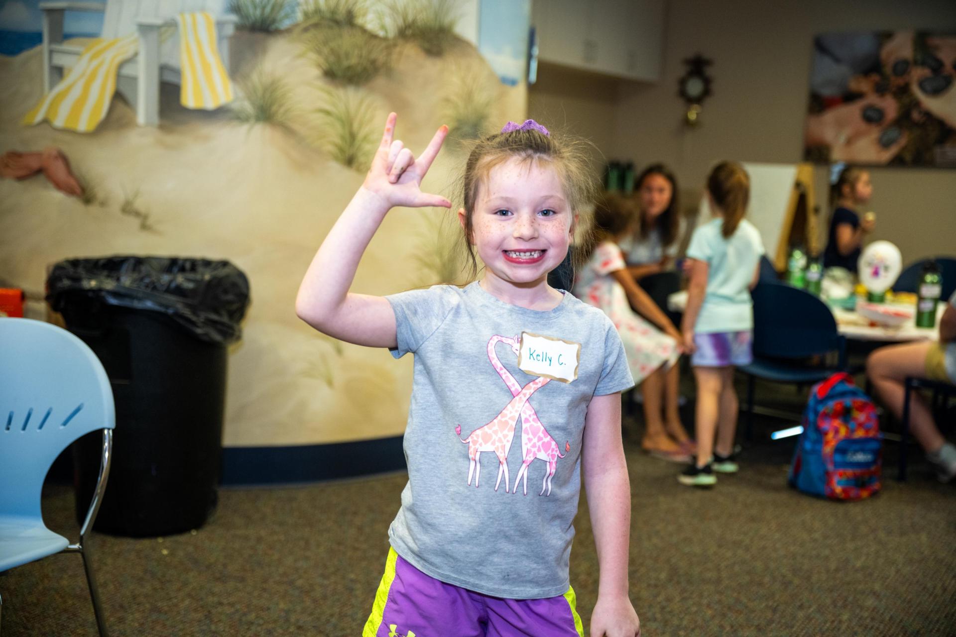 Smiling kid making a cool hand gesture