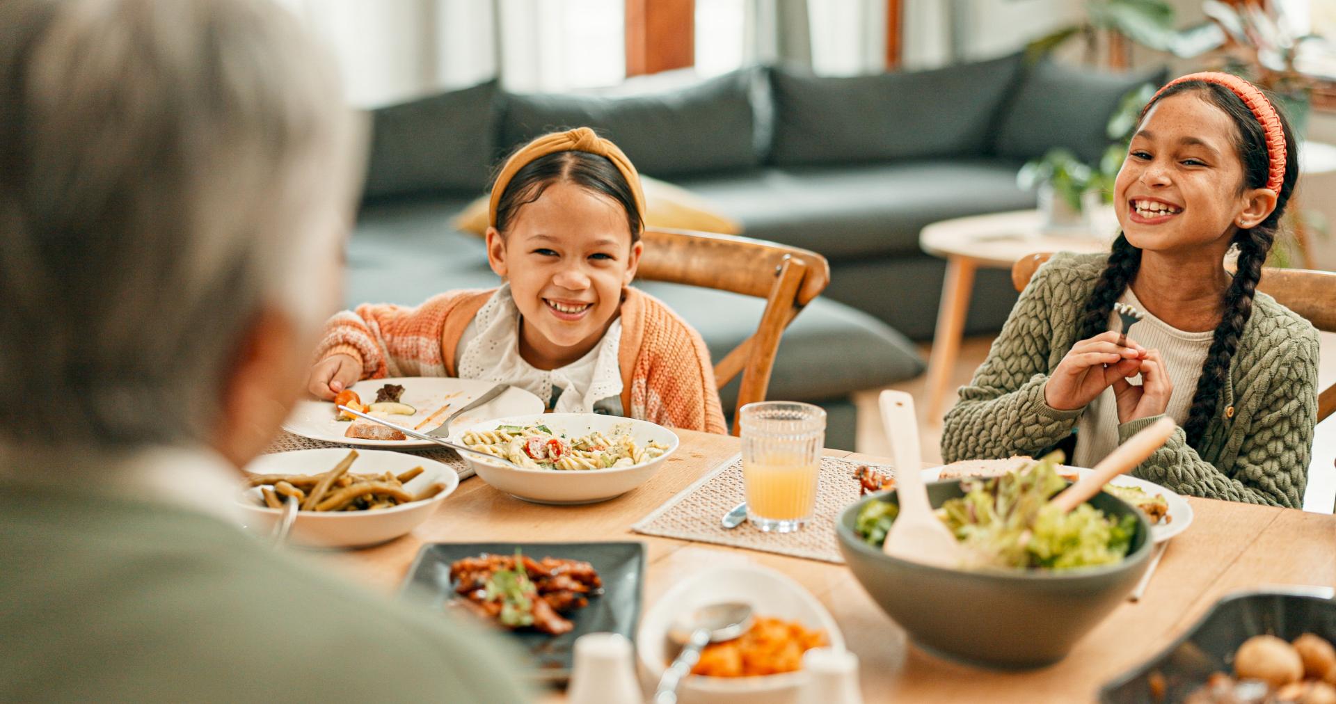 Happy young kids smiling eating a meal