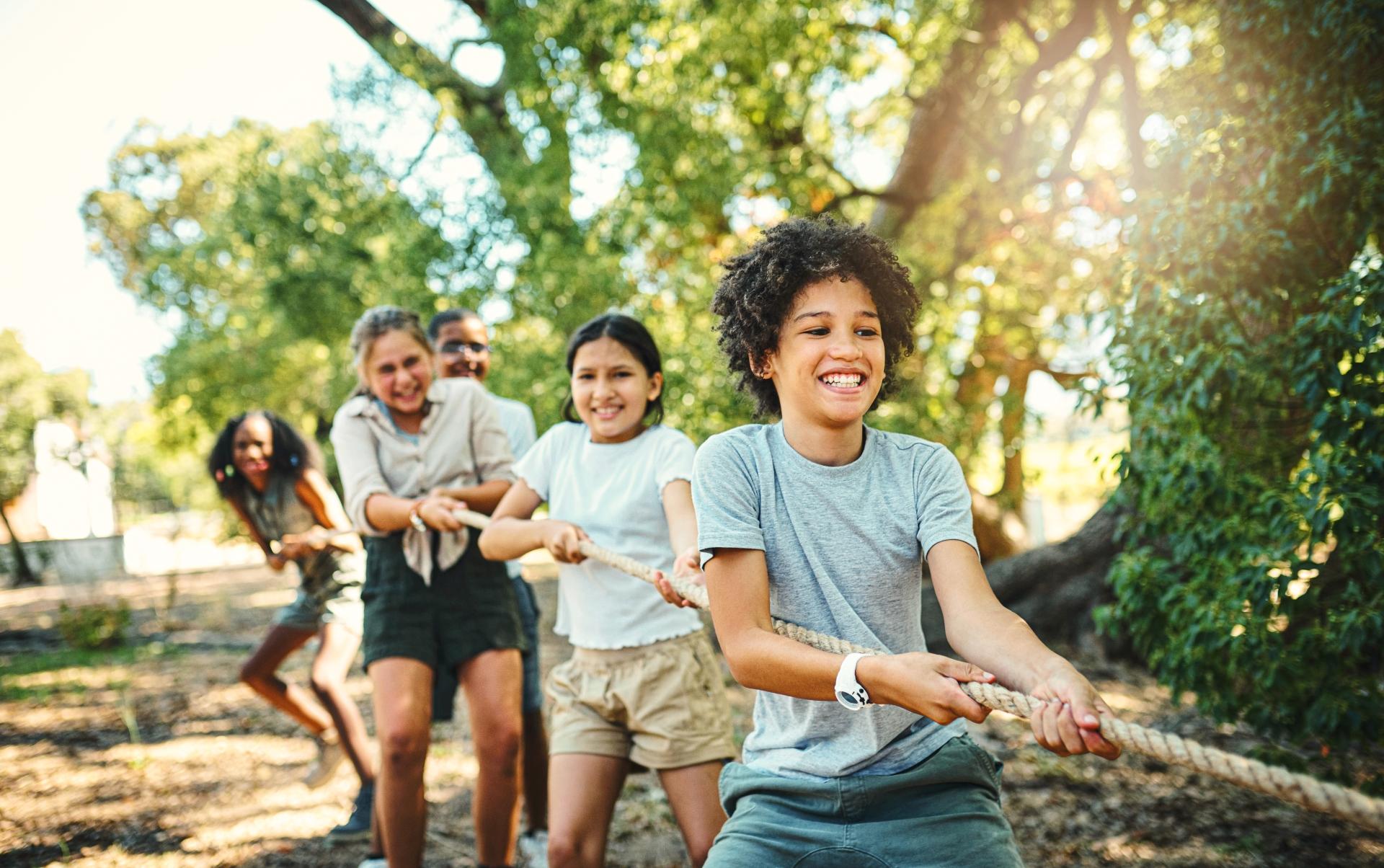 Group of smiling kids playing tug-o-war